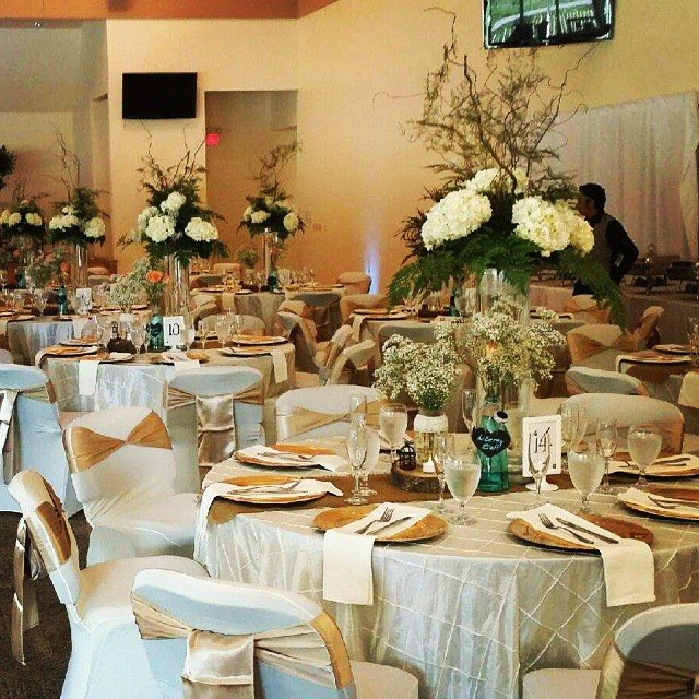Elegant banquet setup with floral centerpieces and gold-accented tableware.