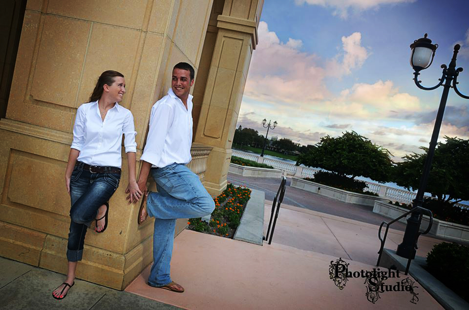 Couple enjoying a scenic sunset on a balcony by the water.