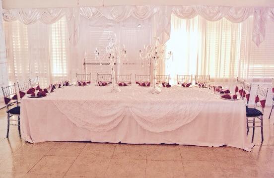 Elegant wedding cake table adorned with floral arrangements and candles.