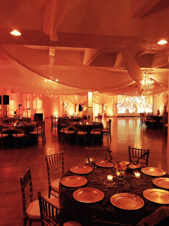 Elegant banquet hall with warm lighting and round tables set for an event.