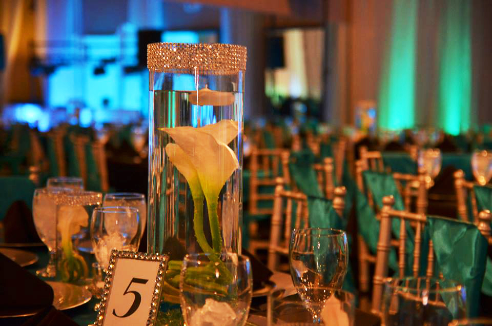Elegant table centerpiece with calla lilies and candles at a formal event.