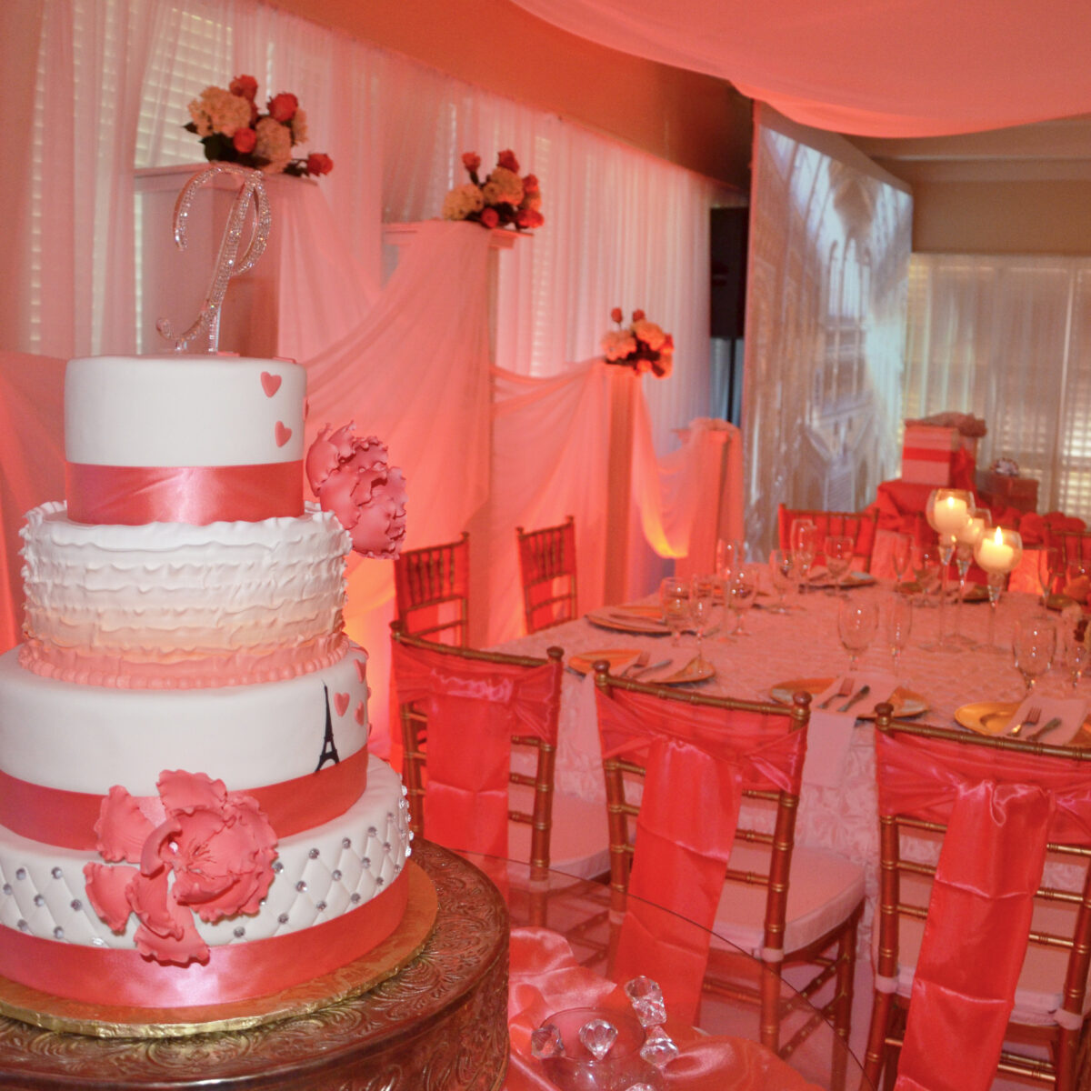 Elegant pink-themed wedding cake and table setup with floral decorations.